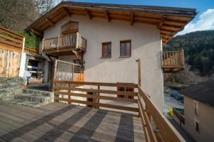 a house with a balcony and a wooden fence at Maison Caramel Chalet in Landry