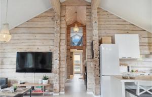 a living room with wooden walls and a flat screen tv at Gorgeous Home In Væggerløse With Sauna in Marielyst