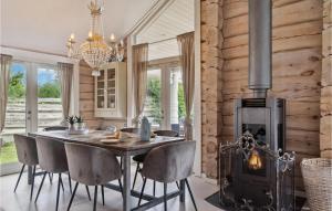 a dining room with a table and a fireplace at Gorgeous Home In Væggerløse With Sauna in Marielyst