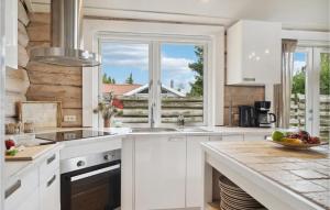 a kitchen with white cabinets and a large window at Gorgeous Home In Væggerløse With Sauna in Marielyst