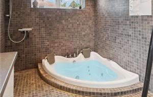 a bath tub in a bathroom with a shower at Gorgeous Home In Væggerløse With Sauna in Marielyst +11 photos
