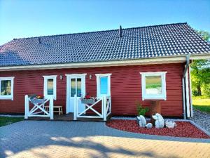 a red house with two teddy bears in front of it at Ferienhaus Lina in Siegmundsburg