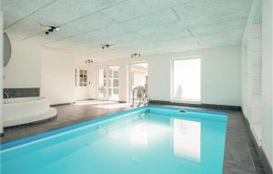 una gran piscina en un baño con bañera en Nice Home In Blokhus With Sauna, en Blokhus