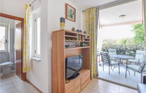 ein Wohnzimmer mit einem TV und einem Tisch mit Stühlen in der Unterkunft Awesome Apartment In Isca Marina With Kitchen in Badolato
