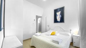 a white bedroom with a white bed and a mirror at Villa Maddalena - Giardinelli in La Maddalena