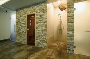 a bathroom with a stone wall and a shower at Nacho by Stellar Hotels, Yerevan in Yerevan