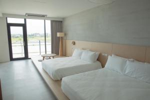Habitación de hotel con 2 camas y ventana en Golden Harvest Homestay, en Toucheng