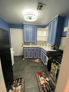 a kitchen with blue cabinets and a stove top oven at Xscapecation Oasis in Tulsa