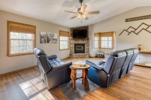 a living room with two leather chairs and a fireplace at Riverbend Escape - Waterfront - Hot Tub - Game Room in Marble