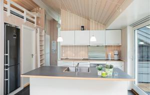 una cocina con armarios blancos y fregadero en Beautiful Home In Pandrup With Wifi, en Rødhus