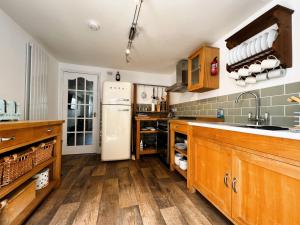 a kitchen with wooden cabinets and a white refrigerator at Chic Listed House with Harbour and River Views in Central Cowes - Walk to top restaurants in East Cowes