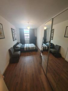 a living room with a bed and a mirror at Double Room with Shared Bathroom in London