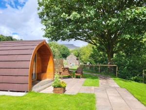 a small shed with a table and chairs in a yard at Ribblesdale Pods in Horton in Ribblesdale