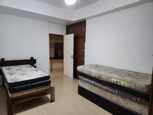 a room with two beds in a room at Apê Pé na Areia 3quartos/2vagas in São Vicente