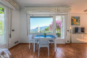 ein Esszimmer mit Tisch und Stühlen und einem Fenster in der Unterkunft Villa Orchidea by PortofinoHomes in Santa Margherita Ligure