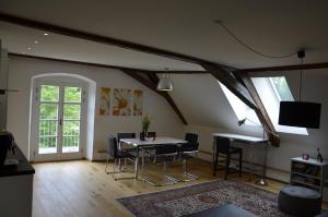 a living room with a table and chairs in a attic at Goldschmiedsmühle in Lindau