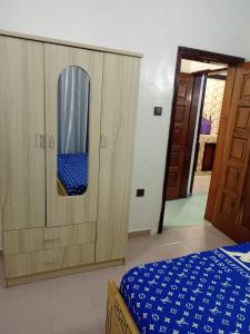 1 dormitorio con 1 cama y armario de madera en Meublés en Cotonú