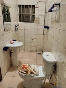 y baño con aseo y lavamanos. en Meublés en Cotonú