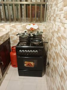 a kitchen with a stove with pots and pans on it at Meublés in Cotonou