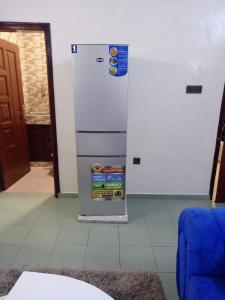 a white refrigerator in a room with a door at Meublés in Cotonou