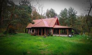dom z czerwonym dachem na zielonym polu w obiekcie Stone cottage 