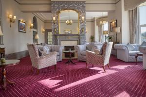 a living room with couches and a fireplace at The Lansdowne, Eastbourne in Eastbourne