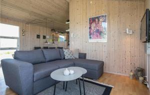 een woonkamer met een blauwe bank en een tafel bij Amazing Home In Lkken With Kitchen in Løkken