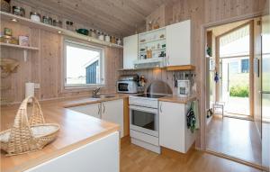 ロッケンにあるStunning Home In Lkken With 2 Bedrooms And Wifiの白い家電製品と木製の壁が備わるキッチン