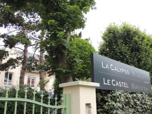 una señal frente a un edificio con una valla en Le Castel Cabourg hôtel & SPA- Restaurant La Calypso en Cabourg