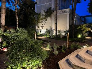 einen Garten vor einem Gebäude in der Nacht in der Unterkunft Le Castel Cabourg hôtel & SPA- Restaurant La Calypso in Cabourg