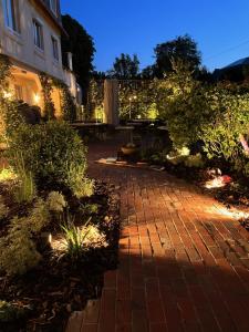 un jardín con una pasarela de ladrillo frente a un edificio en Le Castel Cabourg hôtel & SPA- Restaurant La Calypso en Cabourg