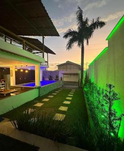 uma casa com uma parede verde e uma palmeira em Cantinho da Praia do Meio em São José de Ribamar