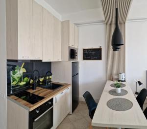 een keuken met witte kasten en een tafel met stoelen bij Studio Tabacariei in Constanţa