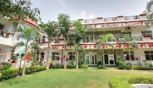 a hotel with a lawn in front of it at Heritage Hotel in Lucknow