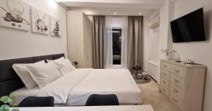 een slaapkamer met een groot wit bed en een tv bij Studio Tabacariei in Constanţa