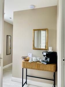 a table with a microwave and a mirror at Le Castel Cabourg hôtel & SPA- Restaurant La Calypso in Cabourg