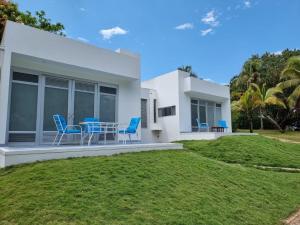 Casa blanca con sillas azules y patio en Finca Summerland ecohotel en Melgar