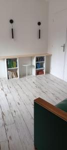 ein Wohnzimmer mit Holzboden und einem Tisch in der Unterkunft Ferme des Ormeaux 