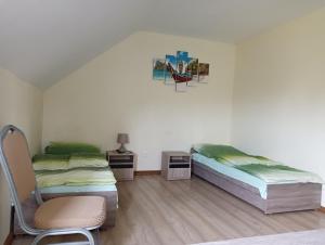 um quarto com duas camas e uma cadeira. em Hotel Romantyczny em Miedzyrzec Podlaski
