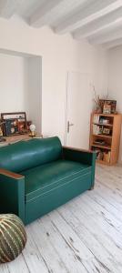 a green couch sitting in a living room at Ferme des Ormeaux 