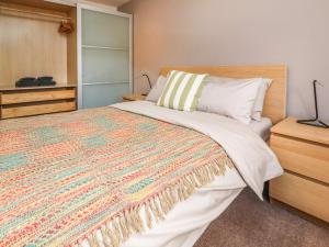 a bedroom with a large bed with a colorful blanket at Palm Court in Carnforth