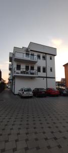 a building with two cars parked in a parking lot at Sweet home in Brčko