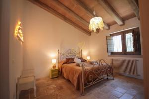 Schlafzimmer mit einem Bett und einem Kronleuchter in der Unterkunft Trulli&Dimore - Trulli di Montaltino in Polignano a Mare
