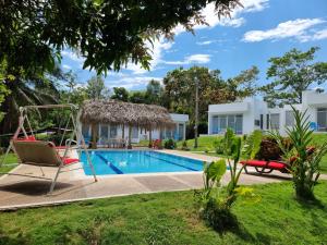 a villa with a swimming pool and a swing at Finca Summerland ecohotel in Melgar
