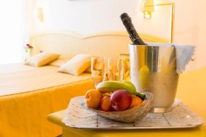 una mesa con un bol de fruta y dos vasos en Hotel Principe en Bibione