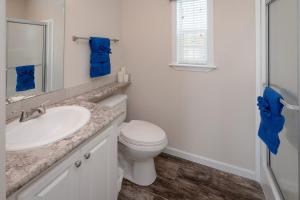 une salle de bain blanche avec un lavabo et des toilettes dans l'établissement Cozy Tiny Home Near Disney World & Orlando Parks!, à Kissimmee 6 autres photos