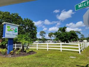 um sinal em frente a uma cerca branca em Cozy Tiny Home Near Disney World & Orlando Parks! em Kissimmee