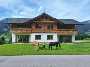 two horses grazing in front of a house at Appartementhaus zum Moserlhof in Ennsling