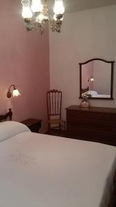 sypialnia z łóżkiem, lustrem i krzesłem w obiekcie La Casa in Campagna w mieście San Martino in Pensilis