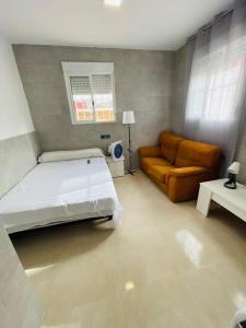 1 dormitorio con 1 cama y 1 sofá en Estudio La Perla, en Ceuta